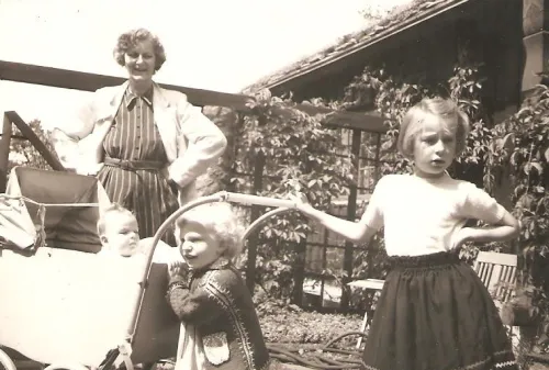 Sort-hvitt foto fra 1953 av Charlotte Koren som barn med mormor og søstrene foran mormorens hus på Lillevann.